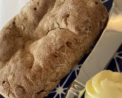 schar's gluten-free ciabatta bun plated with butter and a knife.