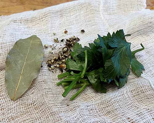 bay leaf peppercorn and parsley on cheesecloth bay leaf peppercorn and parsley on cheesecloth