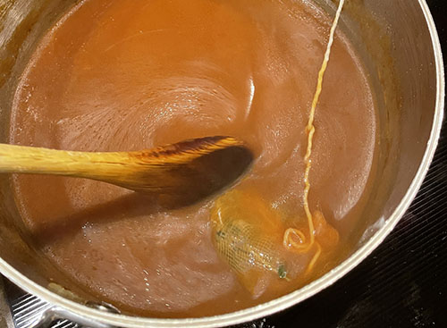 stirring gluten free sauce in brown sauce
