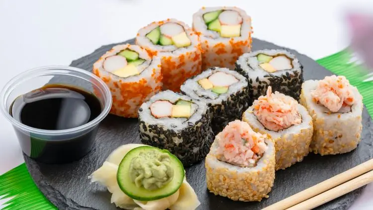 sushi arranged decoratively on a plate with soya sauce on the side