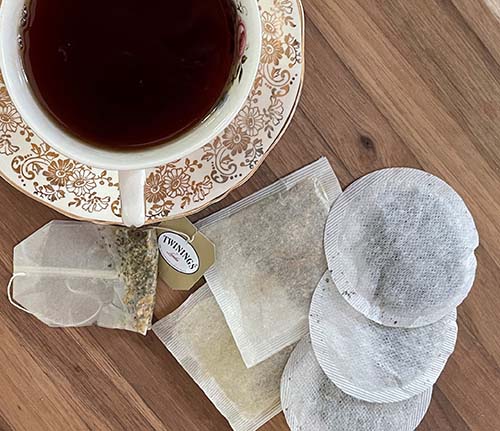 cup of tea on fancy cup and saucer with variety of tea bags.