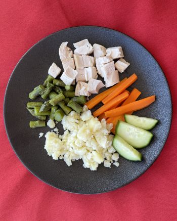 Toddler dinner with cubed chicken, mashed potato, asparagus and carrots