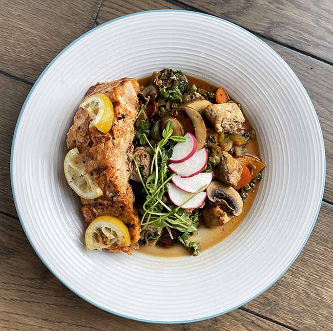 Plate with grilled salmon with side of veggies and mushroom sauce. Plate with grilled salmon with side of veggies and mushroom sauce.