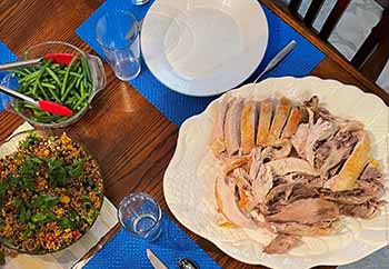 table with a platter of turkey, a bowl of green beans and a quinoa salad table with a platter of turkey, a bowl of green beans and a quinoa salad