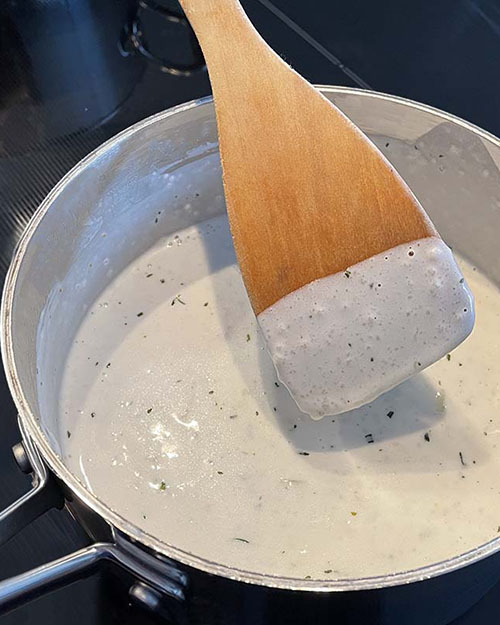 white sauce with wooden spoon