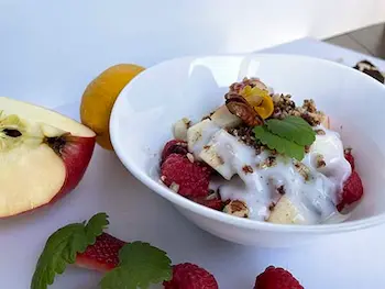 yogurt with berries, nuts and apple in a while bowl yogurt with berries, nuts and apple in a while bowl
